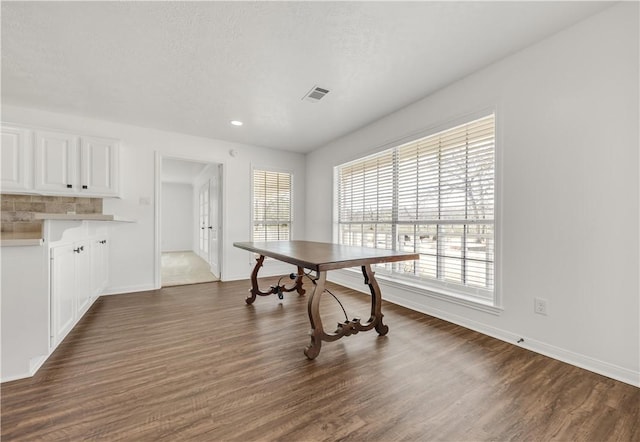 dining area featuring dark hardwood / wood-style floors and a textured ceiling