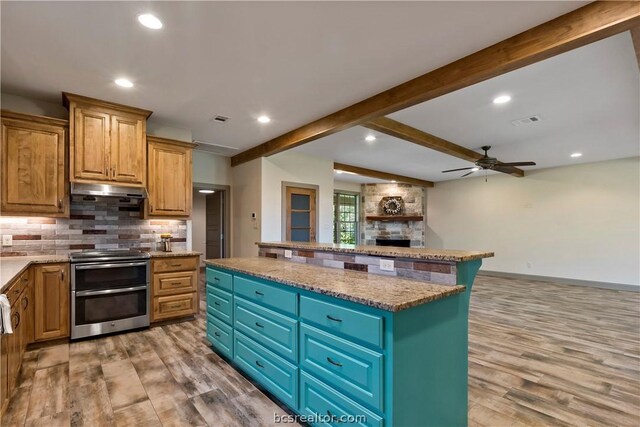 kitchen with a kitchen island, ceiling fan, beamed ceiling, light hardwood / wood-style floors, and stainless steel electric range oven