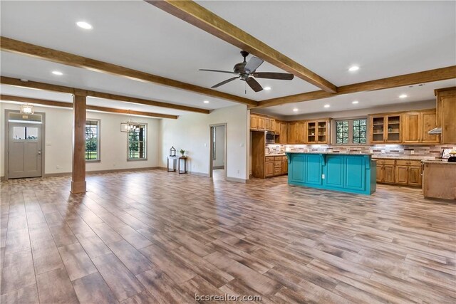 kitchen with a center island, decorative backsplash, light hardwood / wood-style floors, and beamed ceiling