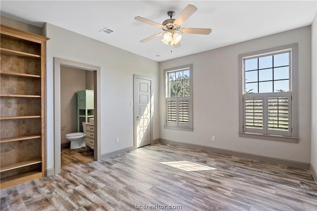 unfurnished bedroom with connected bathroom, ceiling fan, and light wood-type flooring