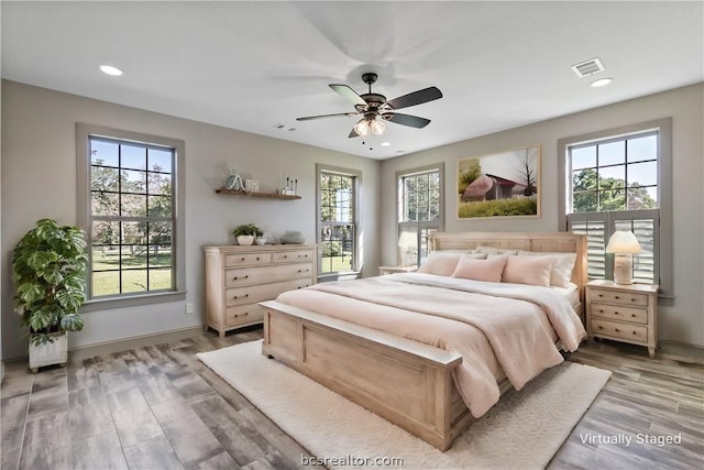 bedroom featuring multiple windows, ceiling fan, and wood-type flooring