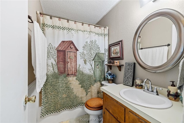 bathroom with vanity, a textured ceiling, and toilet