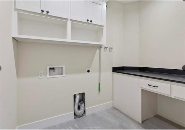 clothes washing area with cabinet space, electric dryer hookup, hookup for a washing machine, and baseboards