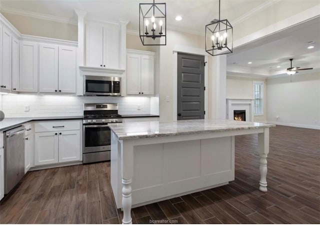 kitchen with ornamental molding, stainless steel appliances, open floor plan, dark wood-style floors, and backsplash