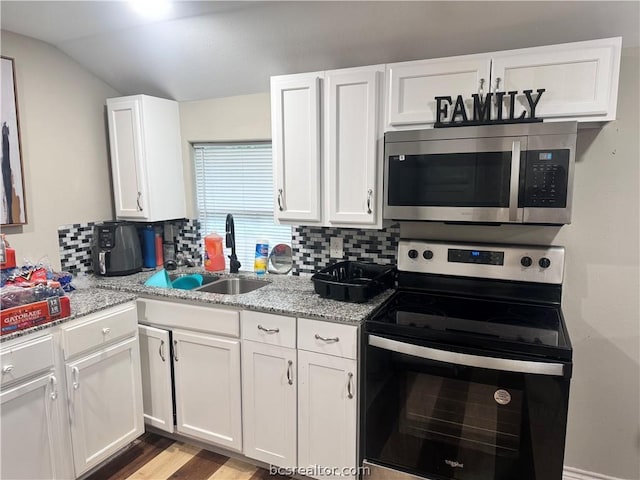 kitchen with backsplash, sink, white cabinets, and stainless steel appliances