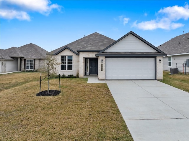 ranch-style home with central AC unit, a front yard, and a garage