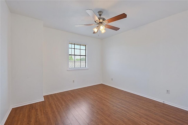 spare room featuring ceiling fan, wood finished floors, and baseboards