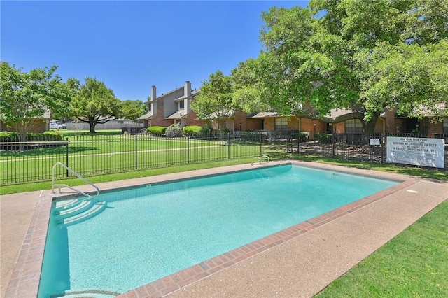 community pool with fence and a lawn