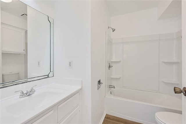 full bathroom featuring baseboards, toilet, wood finished floors, tub / shower combination, and vanity