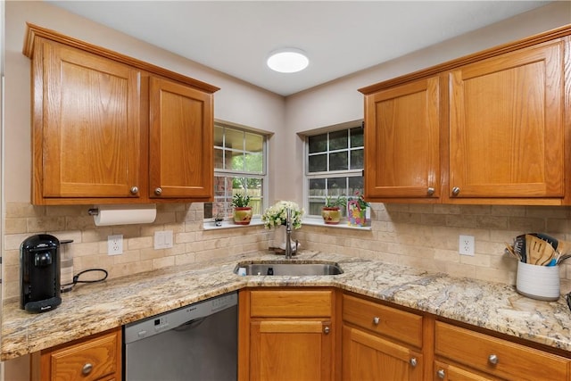 kitchen featuring light stone counters, decorative backsplash, stainless steel dishwasher, and a sink