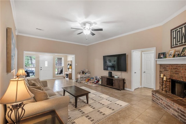 living room featuring light tile patterned floors, ceiling fan, a fireplace, baseboards, and crown molding
