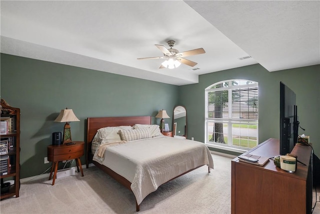 bedroom with a ceiling fan, visible vents, light carpet, and baseboards