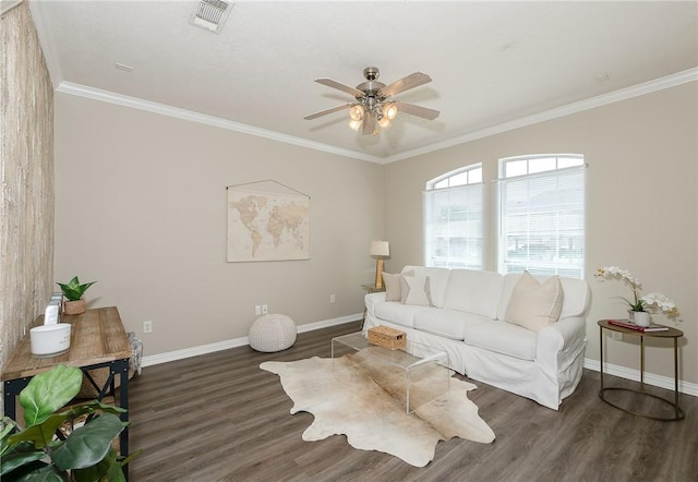 living area with wood finished floors, visible vents, a ceiling fan, ornamental molding, and baseboards