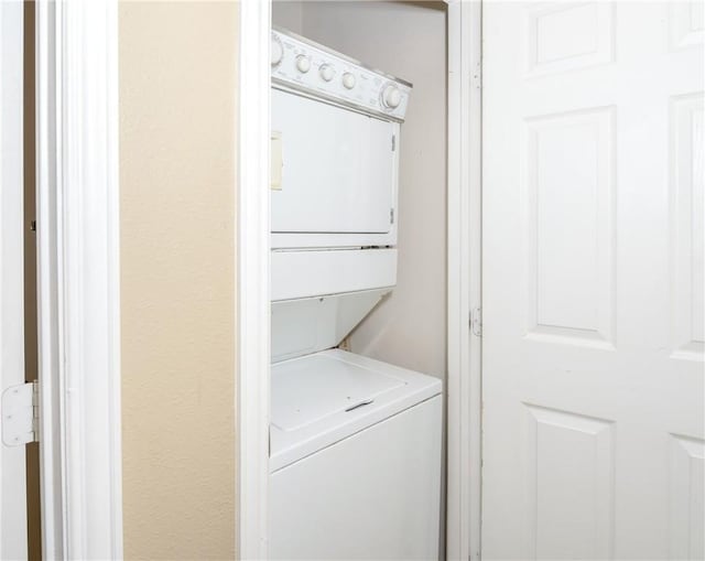 laundry area featuring stacked washer / drying machine and laundry area