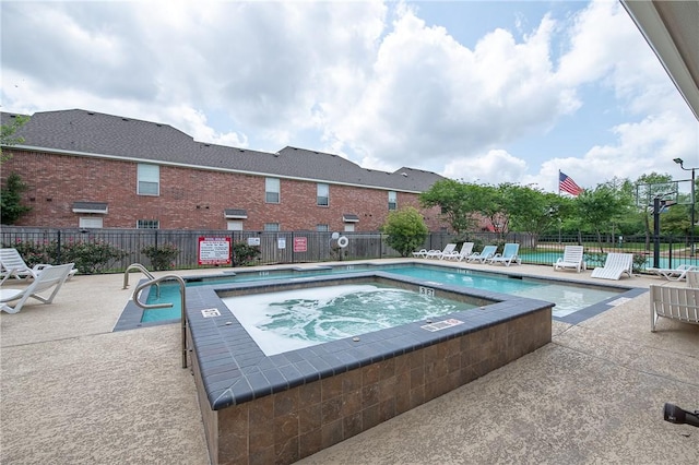 pool featuring fence, a patio area, and a community hot tub