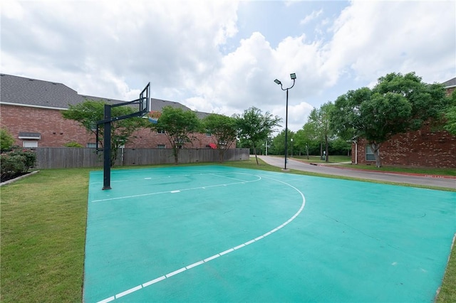 view of basketball court with community basketball court, fence, and a yard