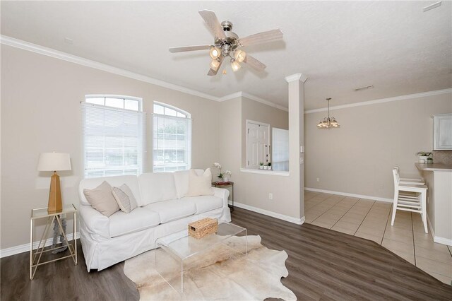 living area with ornamental molding, baseboards, a ceiling fan, and wood finished floors