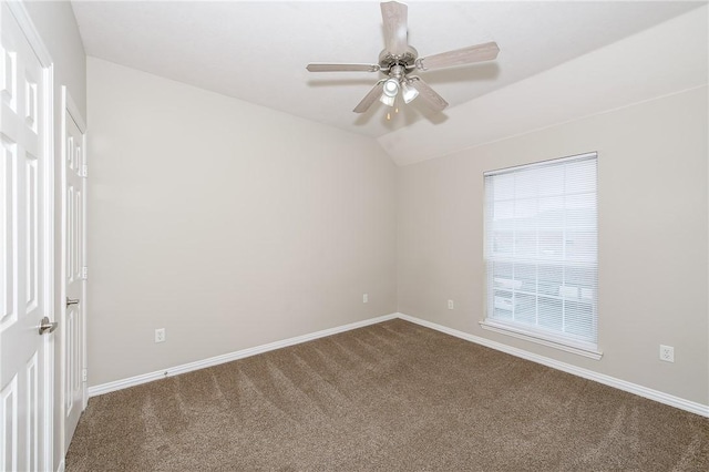 spare room with baseboards, vaulted ceiling, carpet flooring, and ceiling fan