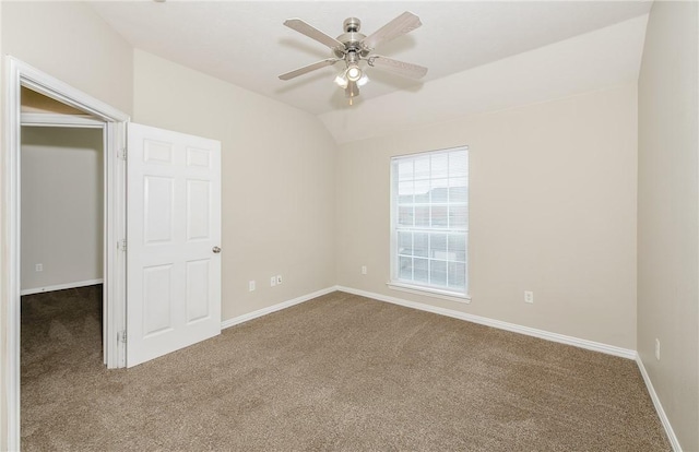 carpeted spare room with ceiling fan, baseboards, and lofted ceiling