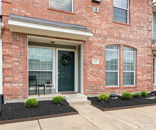 property entrance featuring brick siding