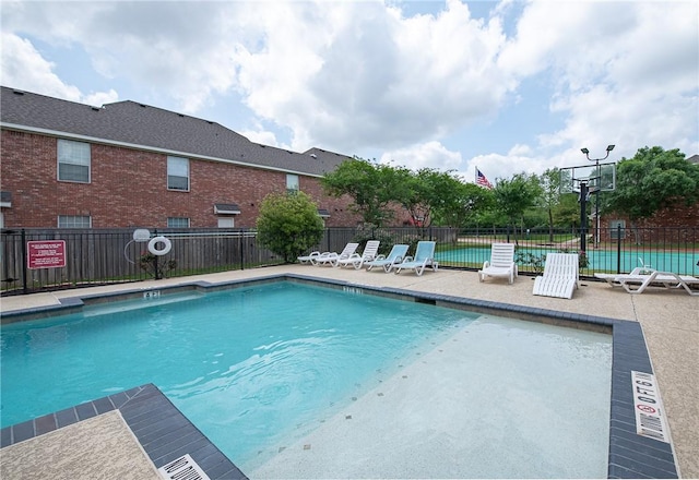 community pool featuring a patio area and fence