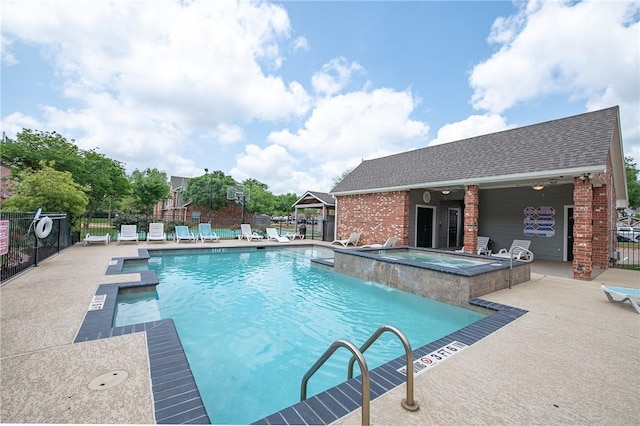 pool featuring a community hot tub, a patio area, and fence