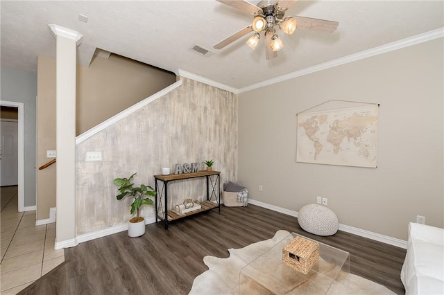 living area featuring wood finished floors, visible vents, a ceiling fan, and baseboards