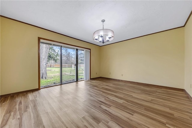 unfurnished room with a chandelier, light wood-style flooring, crown molding, and baseboards