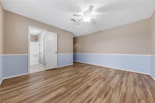 unfurnished room featuring visible vents, baseboards, a ceiling fan, and wood finished floors