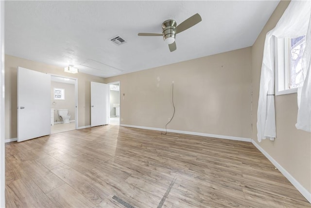 spare room featuring baseboards, light wood-style floors, visible vents, and ceiling fan