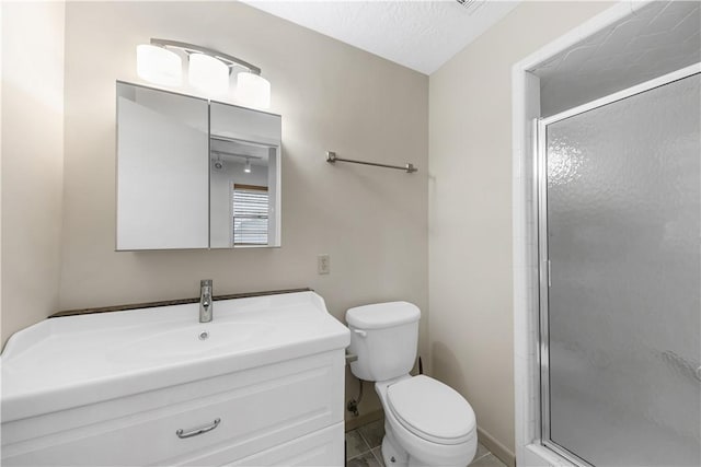 bathroom featuring baseboards, toilet, vanity, a stall shower, and a textured ceiling