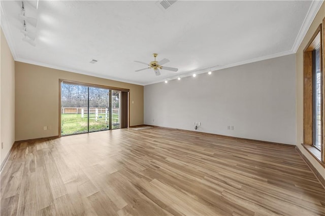 spare room featuring light wood finished floors, visible vents, and crown molding