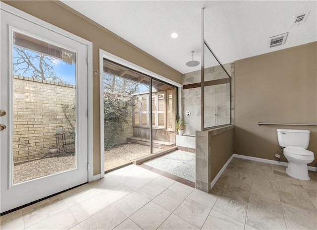 bathroom featuring toilet, baseboards, visible vents, and walk in shower