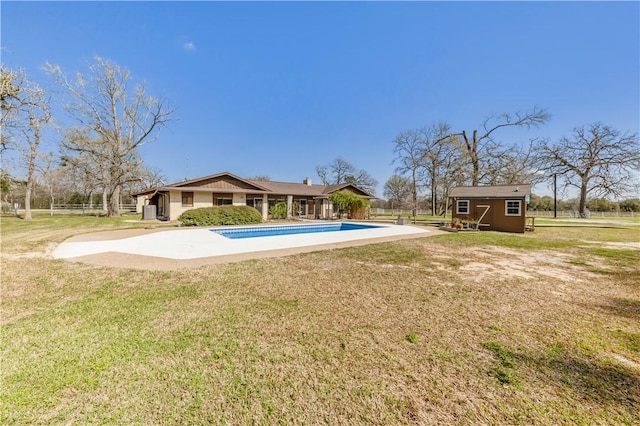 pool with an outbuilding, a lawn, a shed, and fence