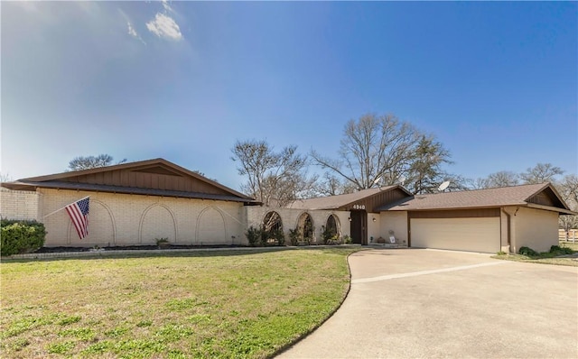 view of front of property with a front lawn, an attached garage, brick siding, and driveway