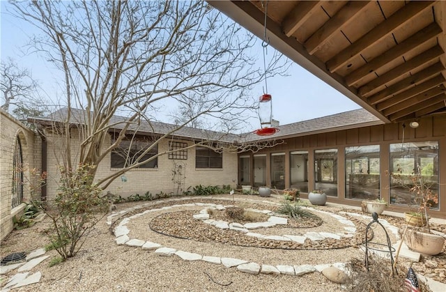 back of property featuring brick siding and a sunroom