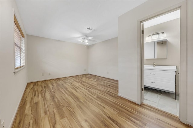 unfurnished bedroom featuring light wood-type flooring, visible vents, baseboards, and ceiling fan