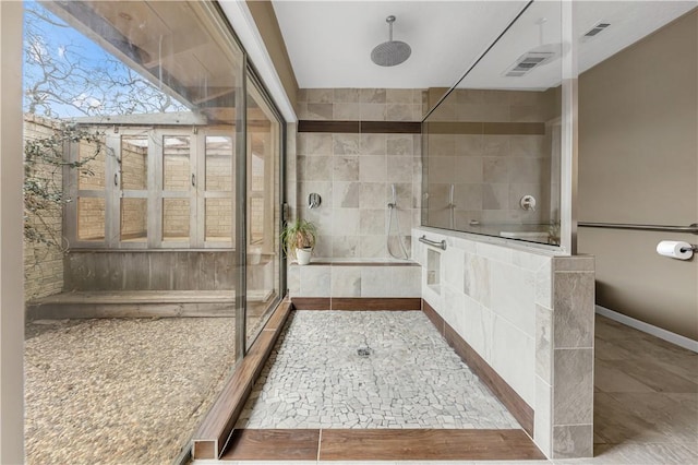 bathroom featuring a tile shower, visible vents, and tile patterned flooring