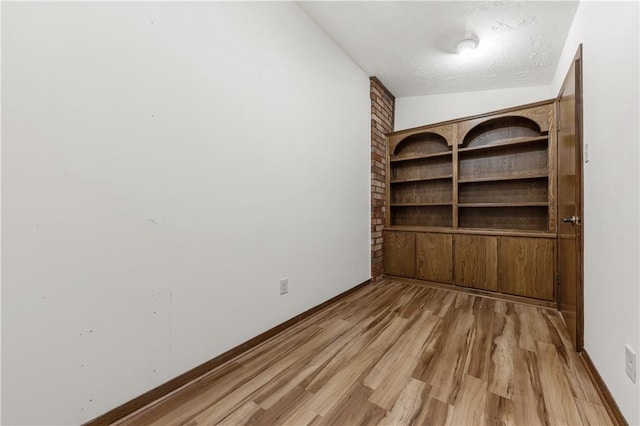 empty room with light wood-style flooring and baseboards