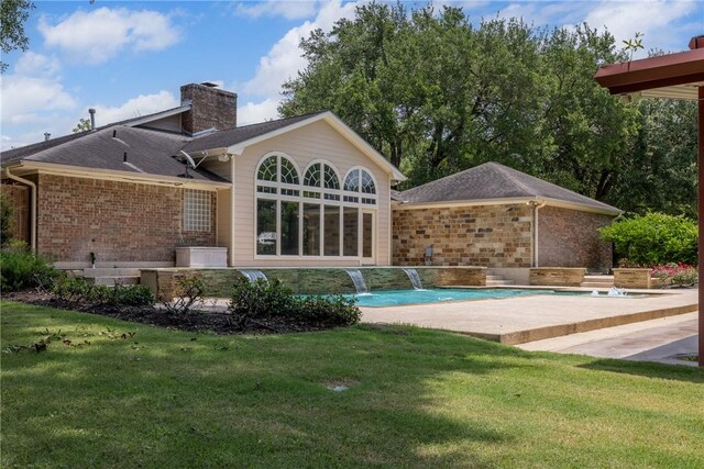 2629 Benton Dr, Brenham, TX 77833 - back of property featuring a lawn, an outdoor pool, a chimney, and brick siding