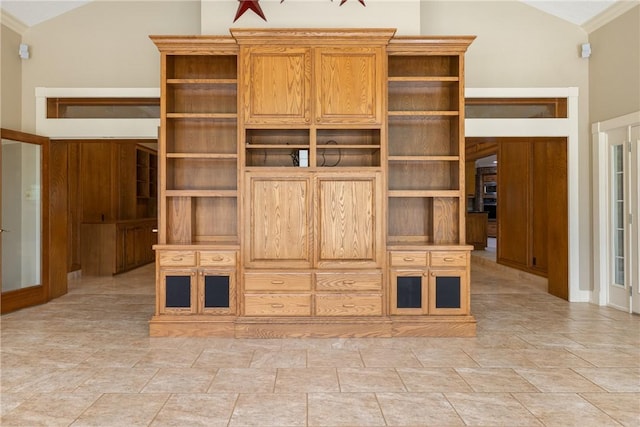 2629 Benton Dr, Brenham, TX 77833 - unfurnished living room with vaulted ceiling, light stone finish floors, and crown molding