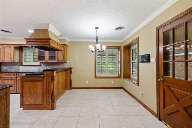 2629 Benton Dr, Brenham, TX 77833 - kitchen featuring custom range hood, dark countertops, decorative backsplash, a chandelier, and brown cabinets