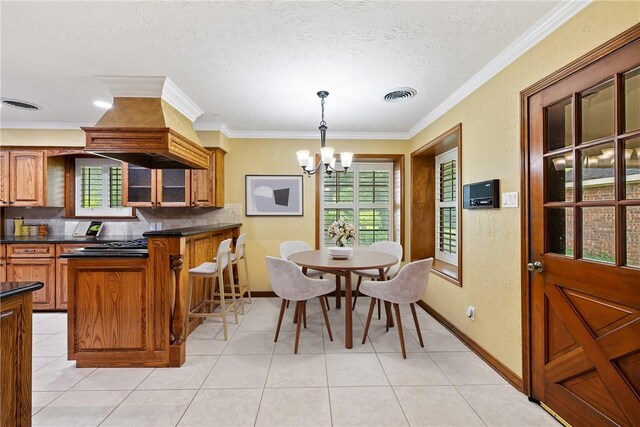 2629 Benton Dr, Brenham, TX 77833 - dining area with a chandelier, light tile patterned flooring, ornamental molding, and a textured ceiling