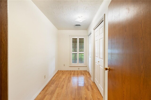 2629 Benton Dr, Brenham, TX 77833 - hallway featuring light wood-style floors and a textured ceiling