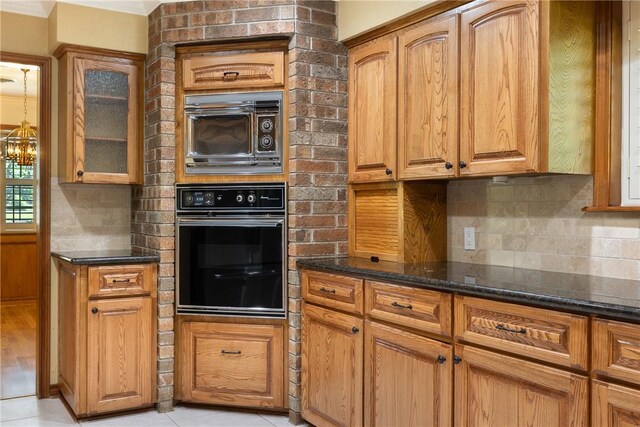 2629 Benton Dr, Brenham, TX 77833 - kitchen featuring oven, dark stone countertops, glass insert cabinets, backsplash, and ornamental molding