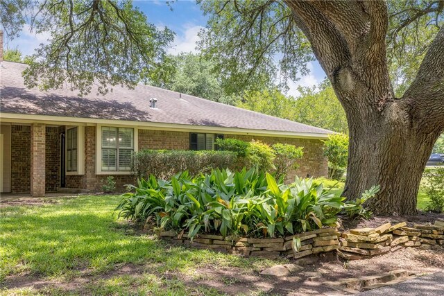 2629 Benton Dr, Brenham, TX 77833 - view of side of home with brick siding and a lawn