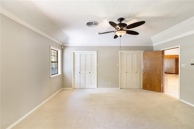 2629 Benton Dr, Brenham, TX 77833 - unfurnished bedroom with two closets, ornamental molding, light carpet, and ceiling fan