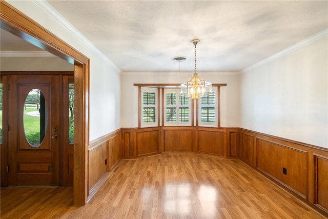 2629 Benton Dr, Brenham, TX 77833 - foyer entrance featuring a wainscoted wall, a chandelier, light wood-style flooring, and crown molding