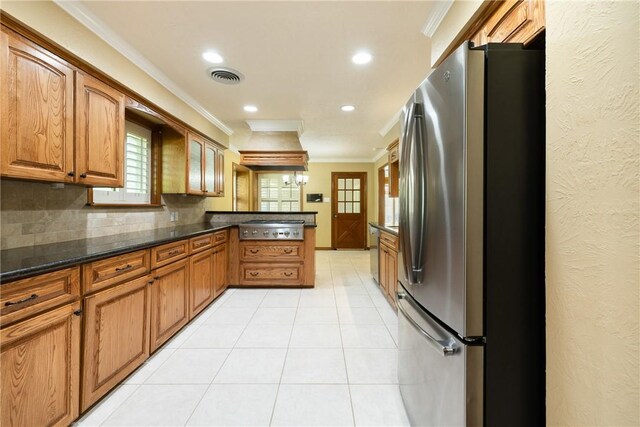 2629 Benton Dr, Brenham, TX 77833 - kitchen with stainless steel appliances, crown molding, a peninsula, tasteful backsplash, and brown cabinetry