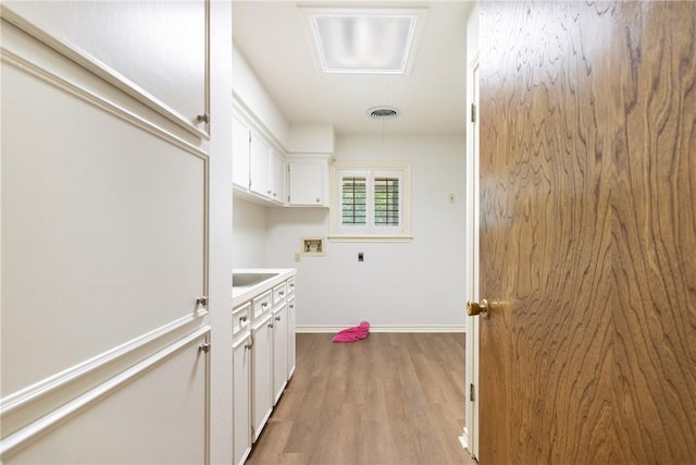 2629 Benton Dr, Brenham, TX 77833 - laundry room featuring hookup for a washing machine, electric dryer hookup, cabinet space, and wood finished floors